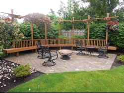 Brick patio hardscaping with two tables and chairs and a wooden frame